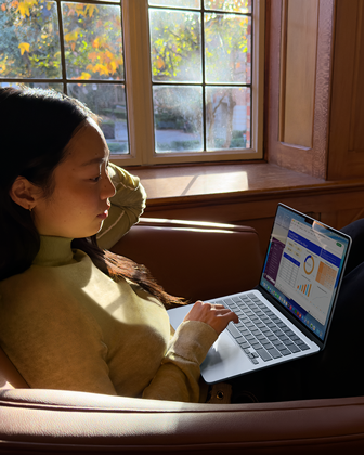 A person sitting in a chair using their MacBook Air