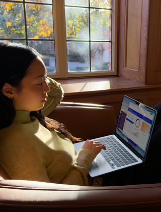 A person sitting in a chair using their MacBook Air