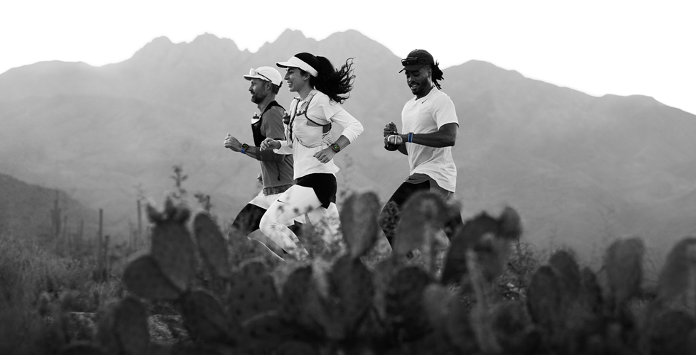 Three people running in a mountainous area, all wearing Apple Watch Ultra 3