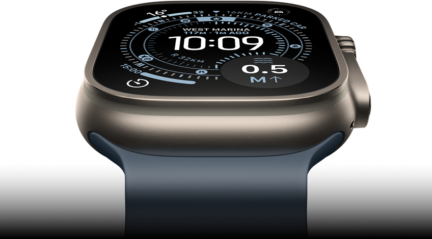 Apple Watch Ultra 3 tilted forward, natural titanium case, compass on Orienteering watch face, anchor blue Ocean Band